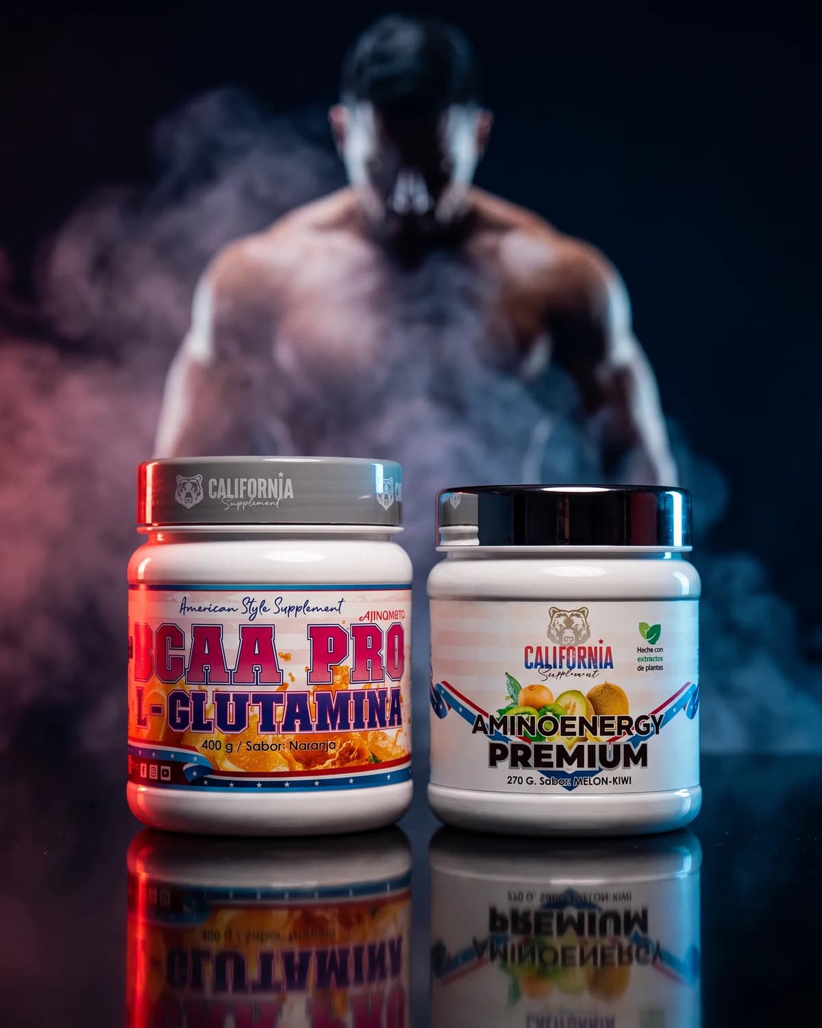 Dos botes de California Supplement, BCAA Pro con L-Glutamina y Aminoenergy Premium, frente a la silueta de un atleta entre humo